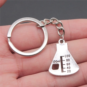 Silver metal keychain featuring a 100ml conical flask pendant held in hand for scale