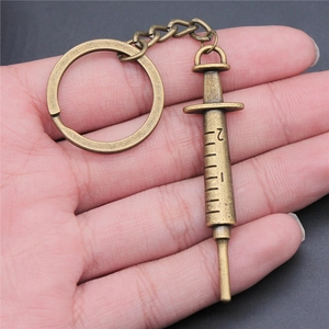 Vintage bronze syringe keychain in zinc alloy with realistic embossed scale details