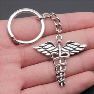 Vintage silver Caduceus medical symbol keychain made of zinc alloy held in hand