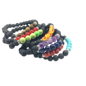 Dettaglio di perline colorate in pietra vulcanica e distanziatori argentati in un set di bracciali