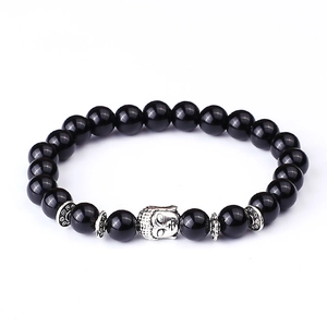 Detailed view of Buddha head charm and polished black energy beads on a stretch bracelet