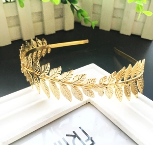 Golden laurel leaf headband hair accessory for weddings and parties on a white frame