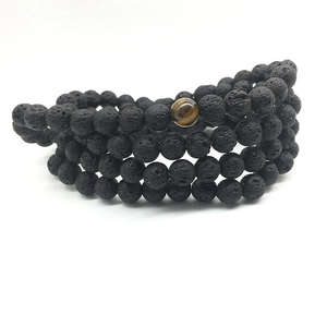 Wikkelarmband met drie lagen van zwarte lavasteen kralen en een accent van tijgeroog steen