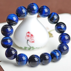 Poliertes blaues Tigerauge-Armband mit Katzenaugeneffekt auf weißer Porzellanvase