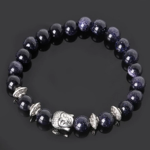 Macro shot of blue sandstone beads with vintage silver Buddha head and textured spacers