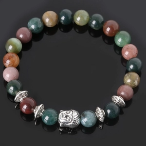 Macro detail of natural stone beads bracelet with a silver Buddha head charm on black surface