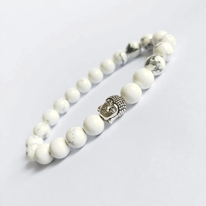 White turquoise Buddha head bracelet with natural grey marble textures on white surface