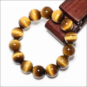 Macro shot of tiger eye stone beads bracelet with golden-brown cat-eye effect shimmer