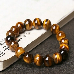 Macro shot of tiger eye stone beads with golden chatoyancy on an open book