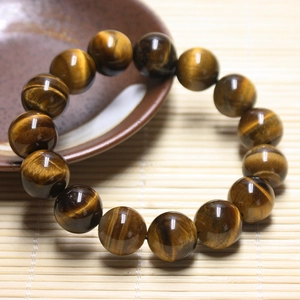 Detailed macro view of natural tiger eye stone beads bracelet on a bamboo mat