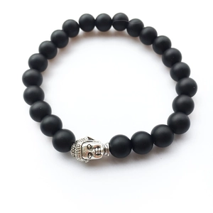 Détail des perles en pierre de lave mate et tête de Bouddha argentée sur bracelet