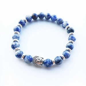 Detailed macro view of blue natural stone beads with a silver Buddha head charm