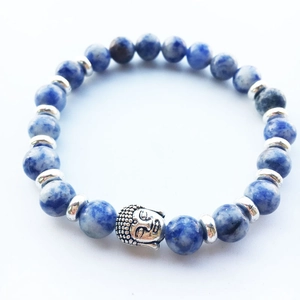 Macro shot of blue marble stone beads with silver Buddha head charm and gear spacers