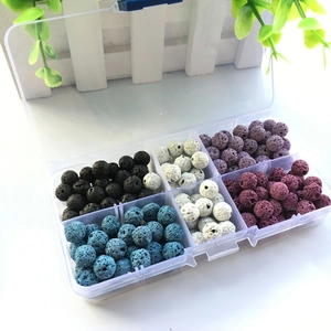 Macro shot of colorful lava stone beads with porous texture in a clear organizer box