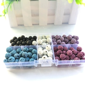 Close-up of multicolored volcanic stone beads in a transparent plastic organizer box
