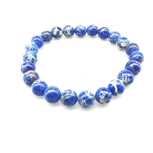 Bracelet en perles de pierre impériale de 8mm avec texture marbrée bleue sur fond blanc