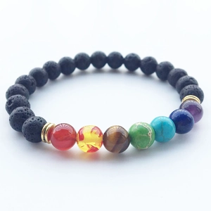 Dettagli macro delle perle chakra colorate e bracciale in pietra lavica con distanziali oro