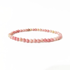 Close-up of 4mm natural pink rhodochrosite crystal beads on an elastic bracelet