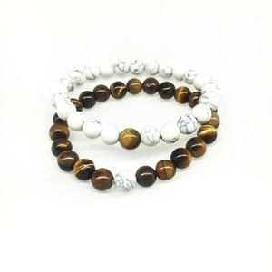 Macro detail of elastic bracelets featuring tiger eye stones and white turquoise beads