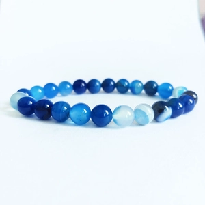 Vue détaillée de perles d'agate à rayures bleues polies sur bracelet élastique