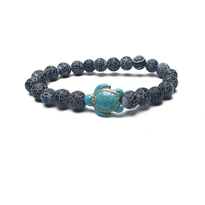 Macro detail of blue turtle pendant with grey crackle beads on elastic bracelet