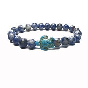 Detail shot of marble-textured blue beads with a turquoise sea turtle charm bracelet