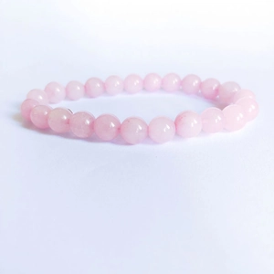Gros plan détaillé des perles de quartz rose de 8mm sur un bracelet extensible en pierre