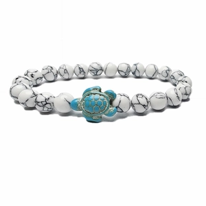 Detail of white marble stone beaded bracelet with a green turquoise turtle charm