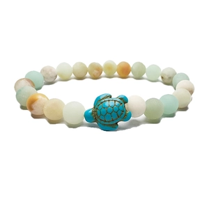 Detailed macro view of beaded turtle bracelet featuring natural matte stones and blue charm