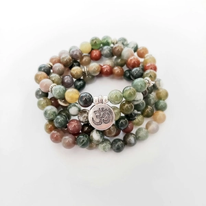 Macro detail of natural Indian agate beads with silver Om pendant and metal spacers
