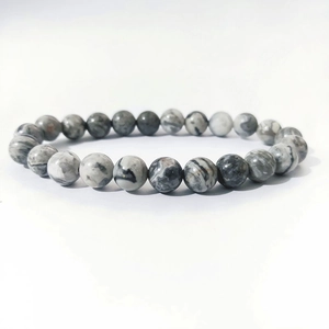 Macro detail of 8mm natural stone beads with unique black and white ink patterns