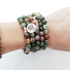 Detail of 108 Indian agate prayer beads with a silver Om charm on a multi-layer bracelet