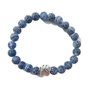 Blue crackle bead bracelet with a silver paw print charm on a clean white background