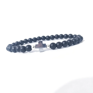 Dettaglio di perline in pietra nera opaca da 6 mm con ciondolo a croce argento su bracciale