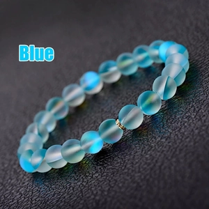 Détail de perles de cristal bleu givré avec lueur aurora et perle dorée sur bracelet