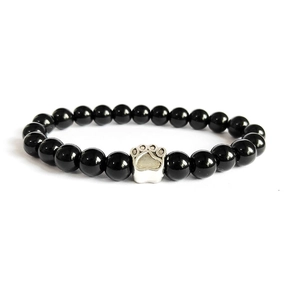Detail of black onyx beaded bracelet featuring a silver metal animal paw print charm