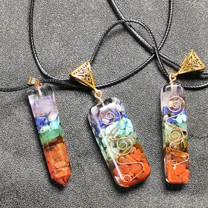 Detailweergave van de zeven chakra-kristallen in orgoniet hars hangers met koper