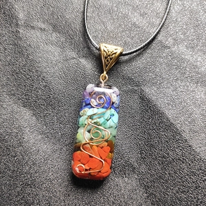 Detail van de 7 chakra stenen hars hanger ketting met koperen spiraal en geweven koord