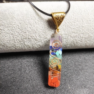 Gedetailleerd zicht op 7 Chakra hars hanger met edelstenen en koperen spiraal decoratie