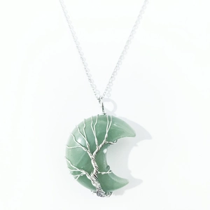 Macro detail of crescent moon pendant with silver wire wrap tree of life on green stone