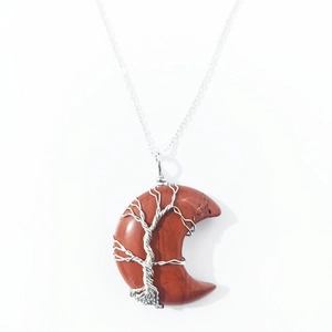 Macro detail of crescent moon pendant with red jasper and tree of life wire wrapping