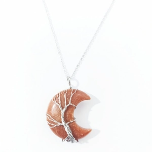 Detailed macro view of orange crystal moon pendant with life tree wire wrapping technique