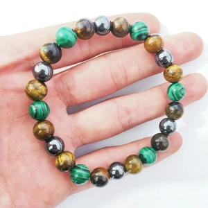 Gros plan détaillé des perles d'œil de tigre, d'hématite et de malachite sur le bracelet