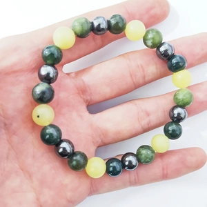 Bracelet en perles de 8mm avec malachite, oeil de tigre et hématite tenu à la main