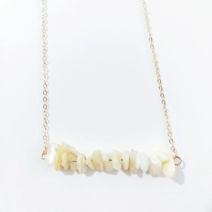 Close-up of irregular natural stone beads on a delicate gold link chain necklace