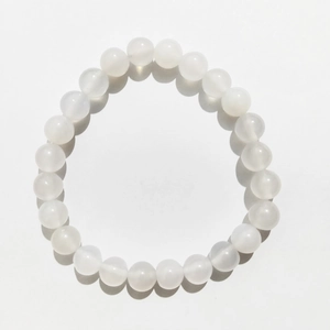Macro detail of 8mm translucent milky white natural gemstone beads on a beaded bracelet