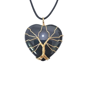 Detailed view of heart-shaped black stone pendant with golden tree of life wire wrapping