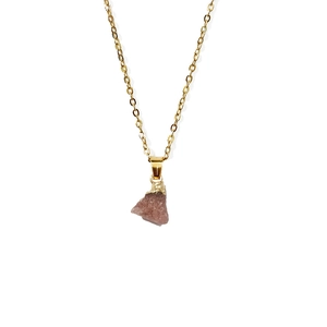 Detail van natuurlijke roze edelsteen hanger met gouden roestvrijstalen ketting