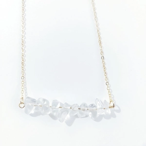 Macro shot of irregular natural white crystal stones on a minimalist gold-tone chain