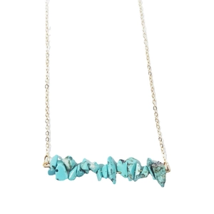 Minimalist gold chain necklace with natural turquoise irregular stones on white background